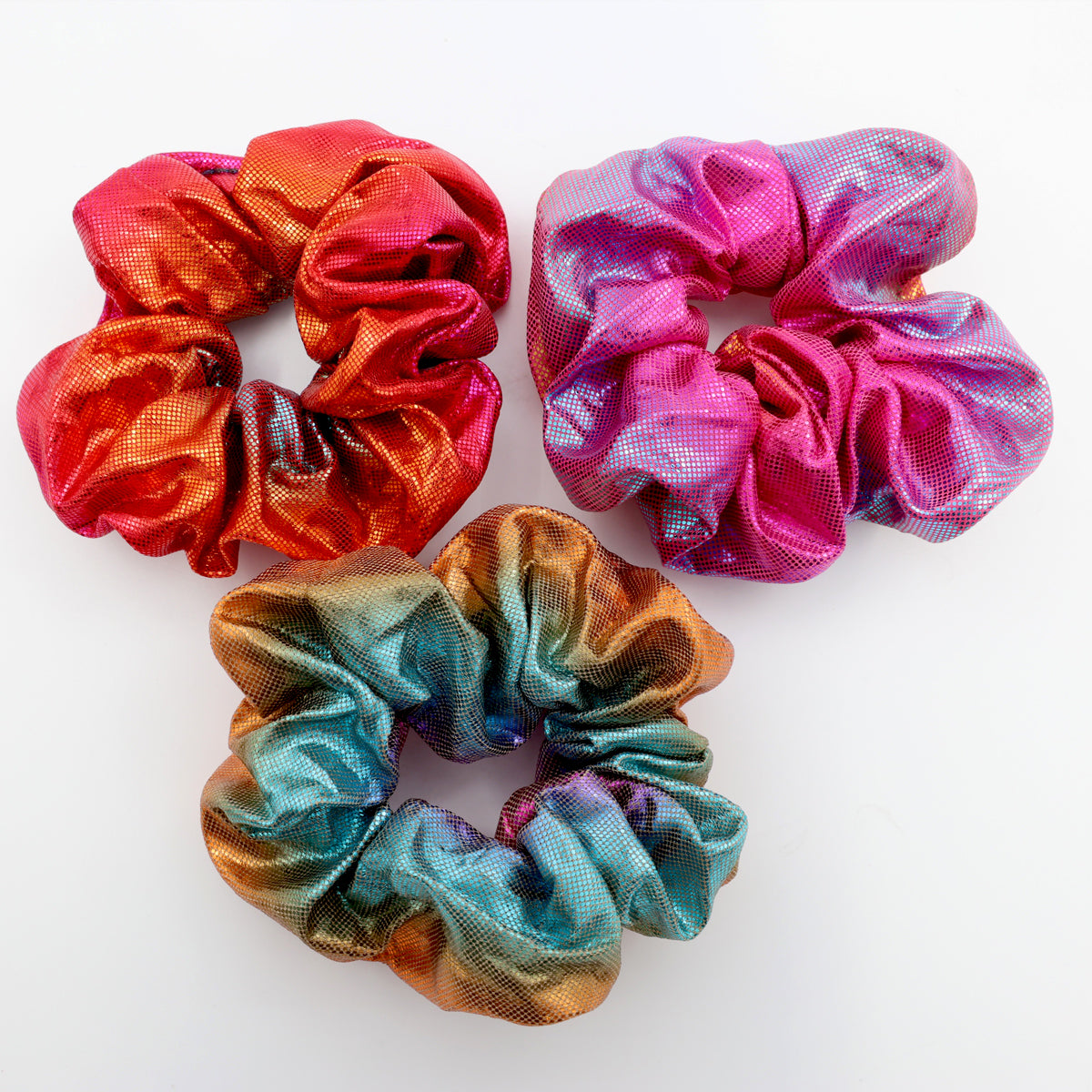 Three colorful scrunchies on a white background