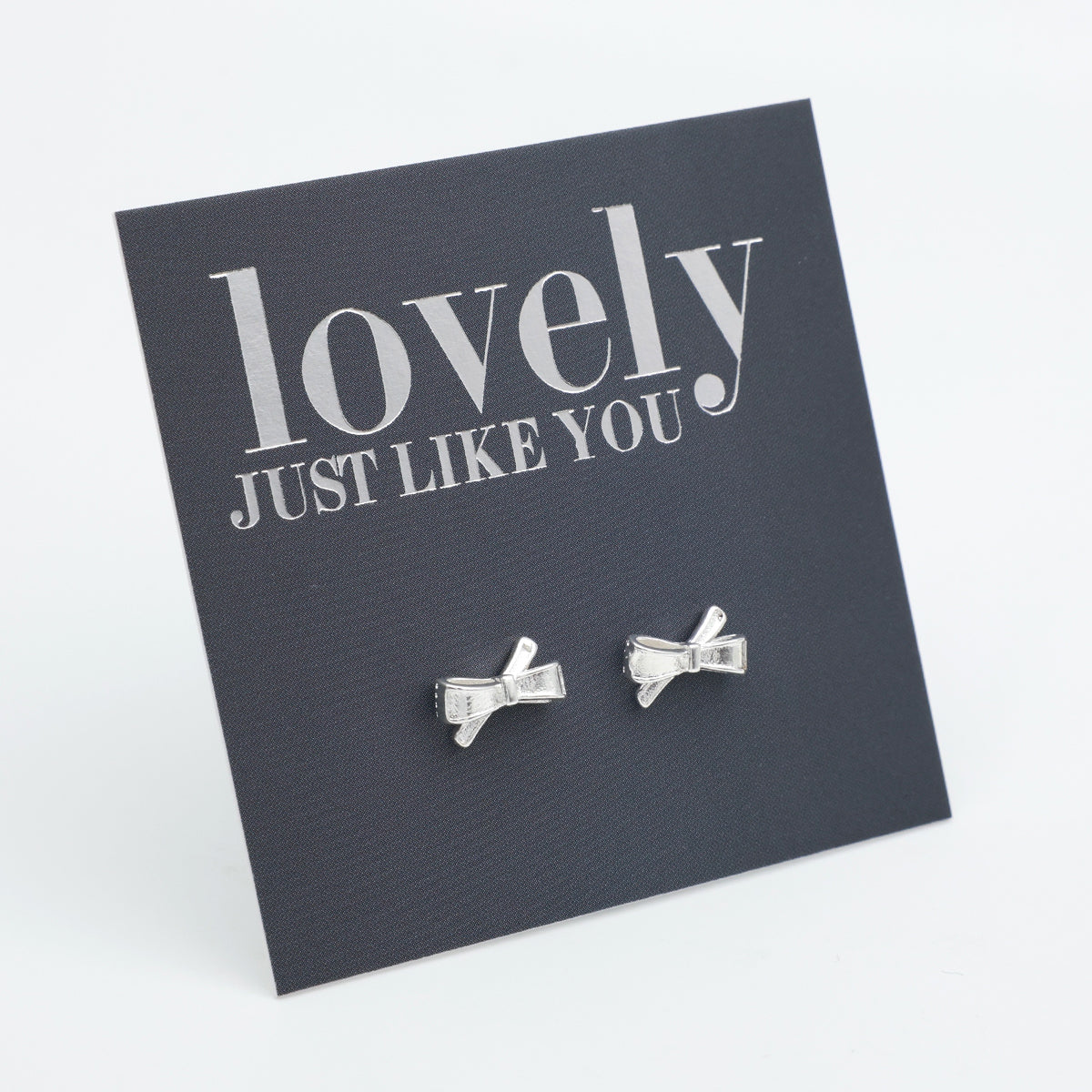 silver bows on a grey card that says "lovely just like you" on a white background 