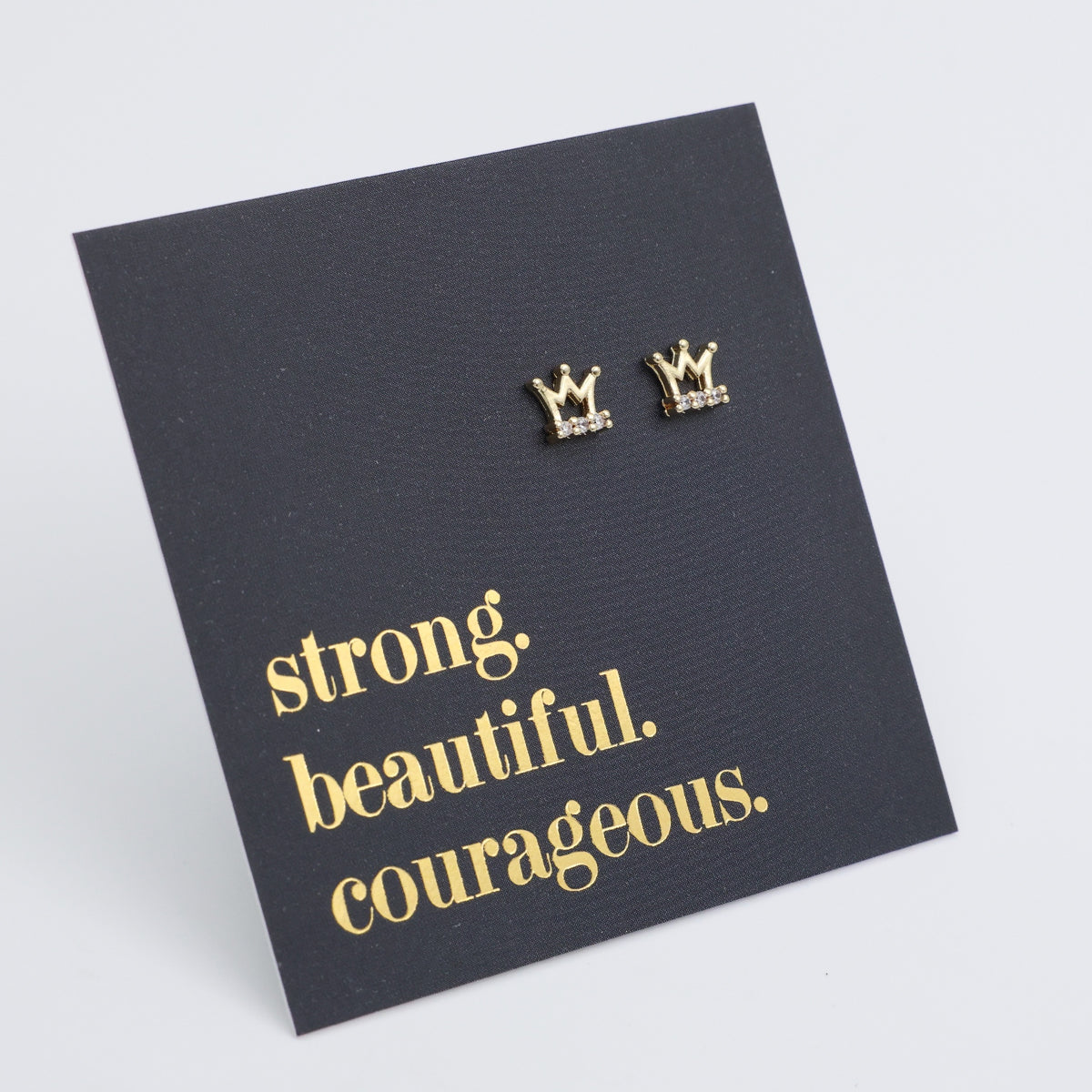 Gold crown earrings on a black card with gold text on a light gray background