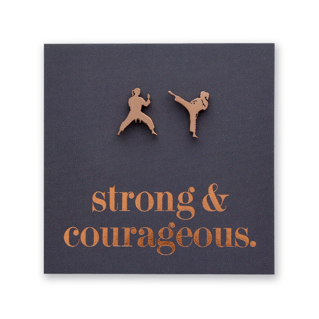 Rose Gold Martial Art Studs on a grey card that says "strong & courageous" in rose gold  writing, on a white background. 
