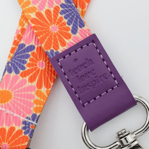 Floral strap with a purple tag and keychain on a white background