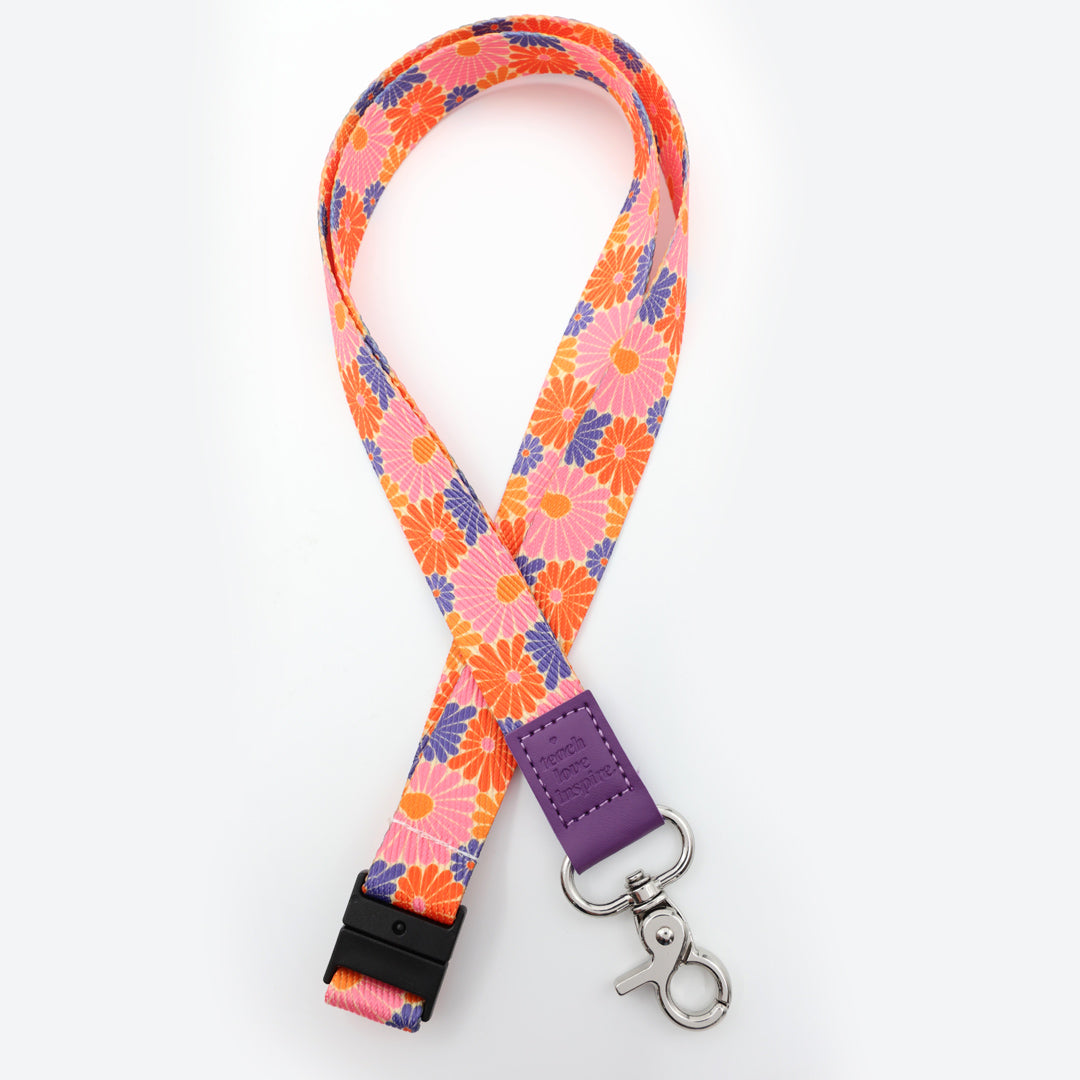 Floral patterned lanyard with a purple strap on a white background