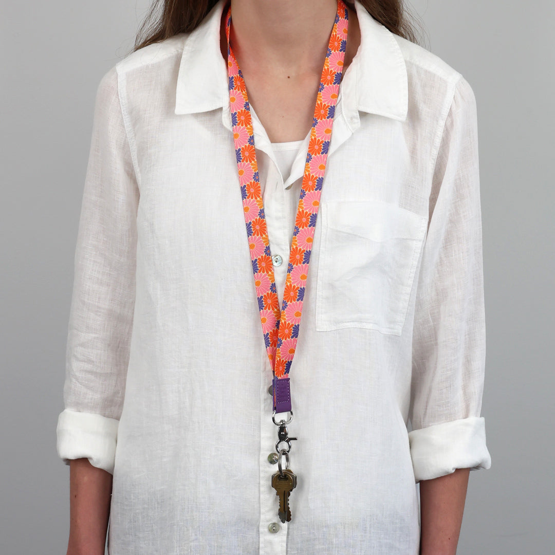 Person wearing a colorful lanyard with keys against a gray background