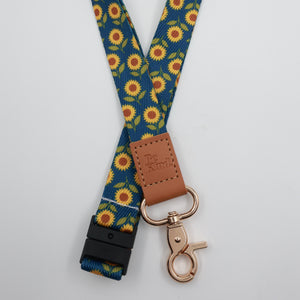 Be Kind embossed on a navy sunflower lanyard with brown trim and a lobster clasp.