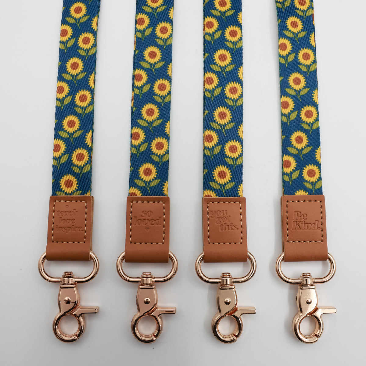 Sunflowers lanyards showing Be Kind, Teach Love Inspire, You Got This and So Loved embossed trims and lobster clasps.