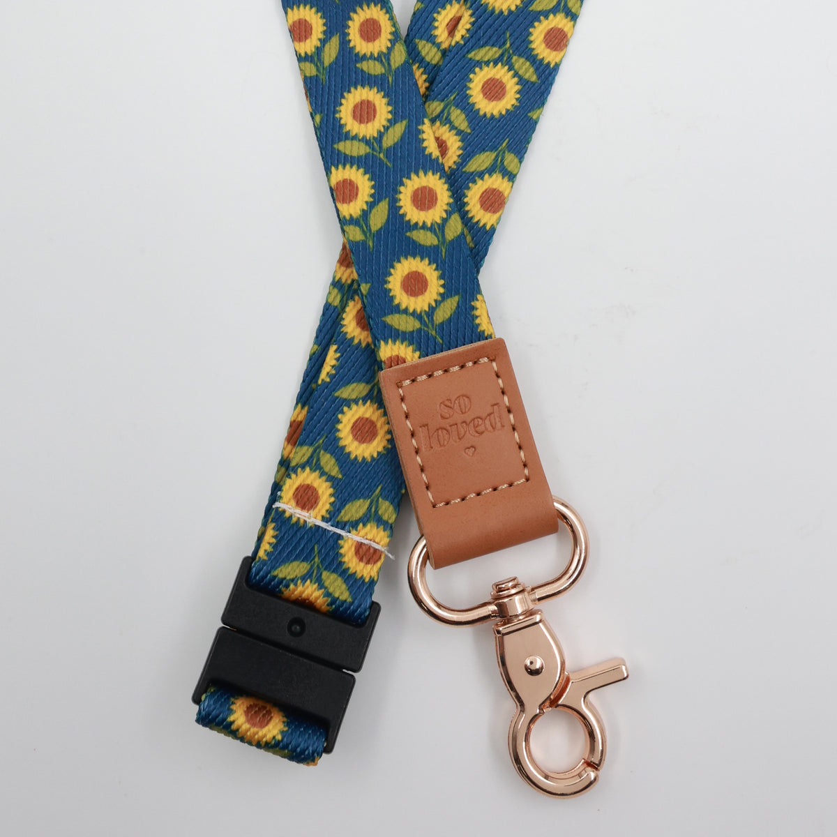 So Loved embossed on a navy sunflower lanyard with brown trim and a lobster clasp.