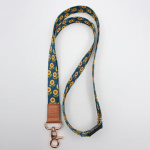 Teach Love Inspire embossed on a navy sunflower lanyard with brown trim and a lobster clasp.