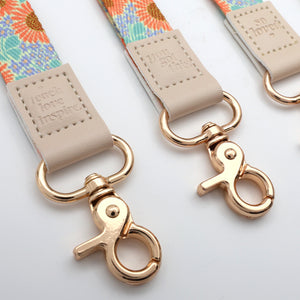Close-up of a floral strap with gold clasp on a white background