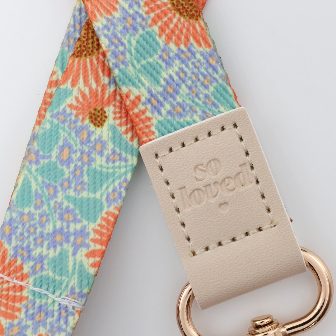 Four floral patterned straps with rose gold hooks on a light gray background
