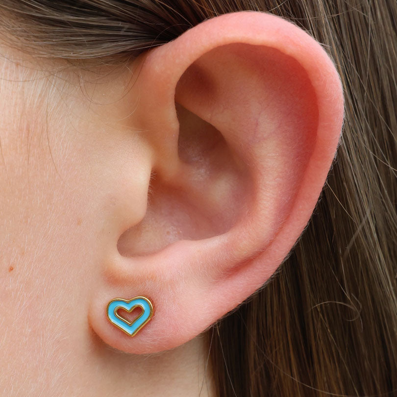 Close-up of an ear wearing a turquoise heart-shaped earring.