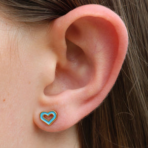 Close-up of an ear wearing a turquoise heart-shaped earring.