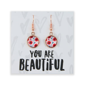 Earrings with floral design on a card with 'You are Beautiful' text