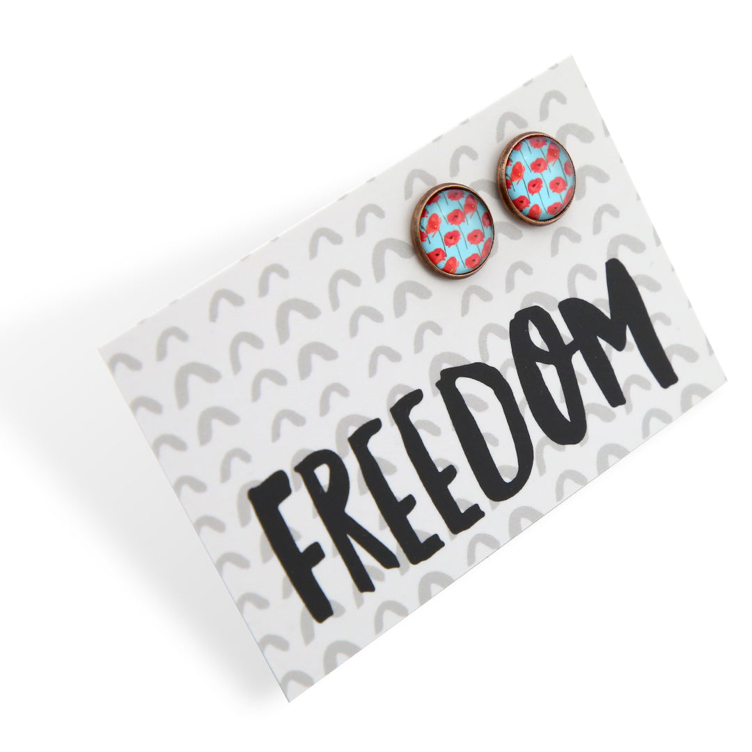 Earrings with floral design on a card with 'FREEDOM' text
