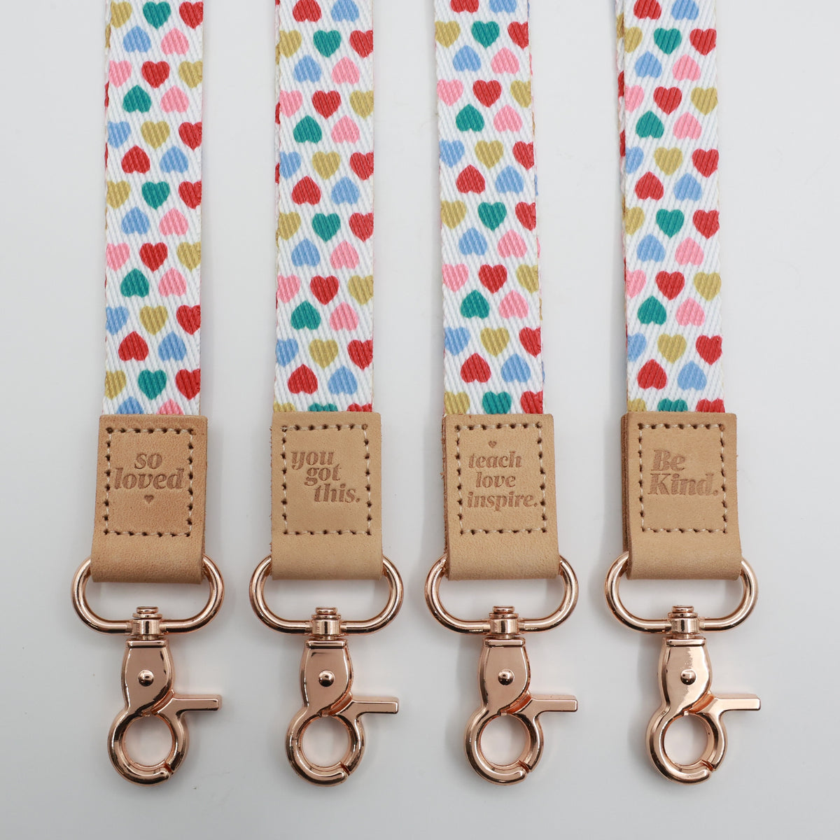 Sweet Hearts lanyards showing Be Kind, Teach Love Inspire, You Got This and So Loved embossed trims and lobster clasps.