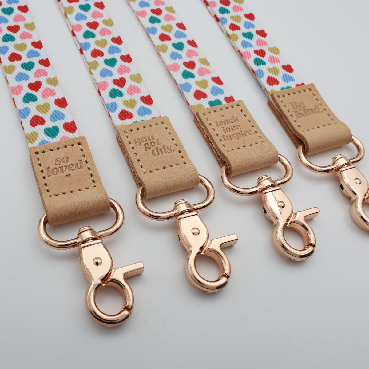 Sweet Hearts lanyards showing Be Kind, Teach Love Inspire, You Got This and So Loved embossed trims and lobster clasps.