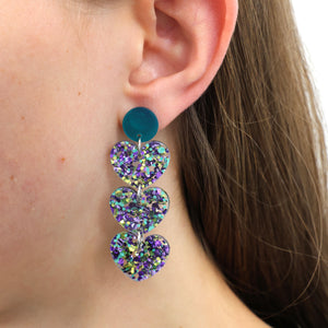 Close-up of a person wearing a colorful heart-shaped earring.