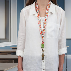 Person wearing a colorful lanyard with keys against a neutral indoor background