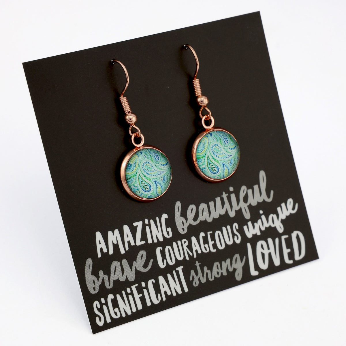Teal paisley print rose gold dangle earrings on amazing inspiring word card on white background.