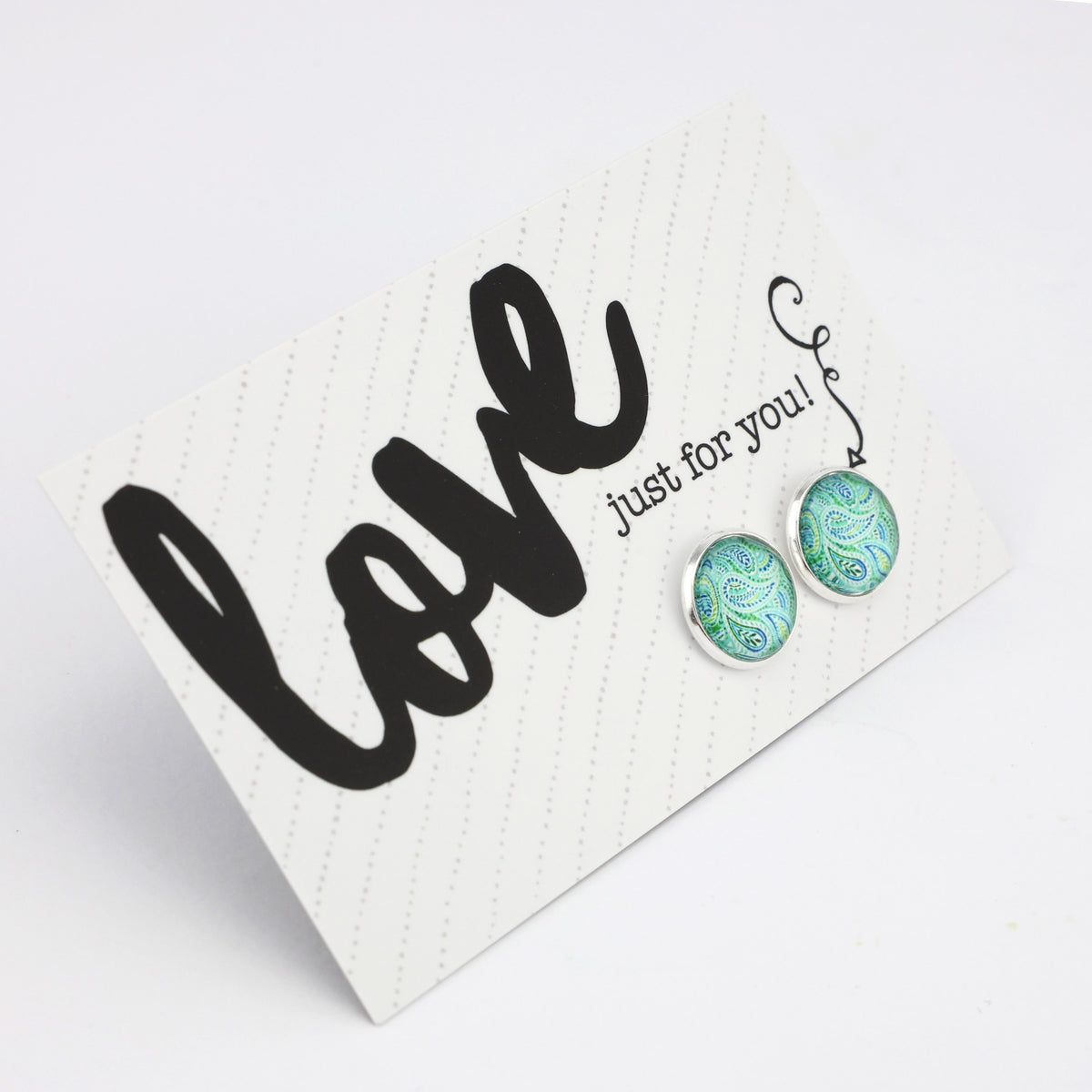 Teal print silver stud earrings on love and inspiring word card on white background.