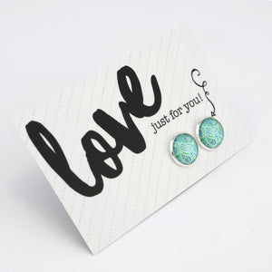 Teal print silver stud earrings on love and inspiring word card on white background.