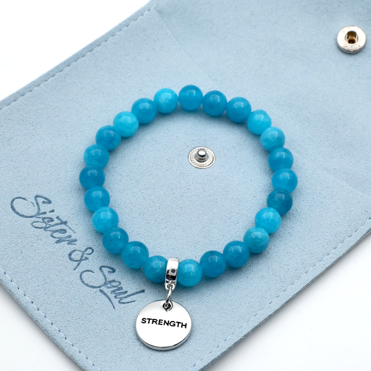 Blue beaded bracelet with a 'STRENGTH' charm on a blue card, featuring the brand 'Sister & Soul'.