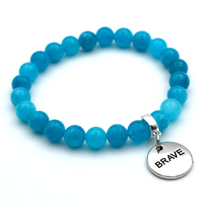 Blue beaded bracelet with a 'BRAVE' charm on a white background