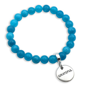 Blue beaded bracelet with a 'GRATEFUL' charm on a white background