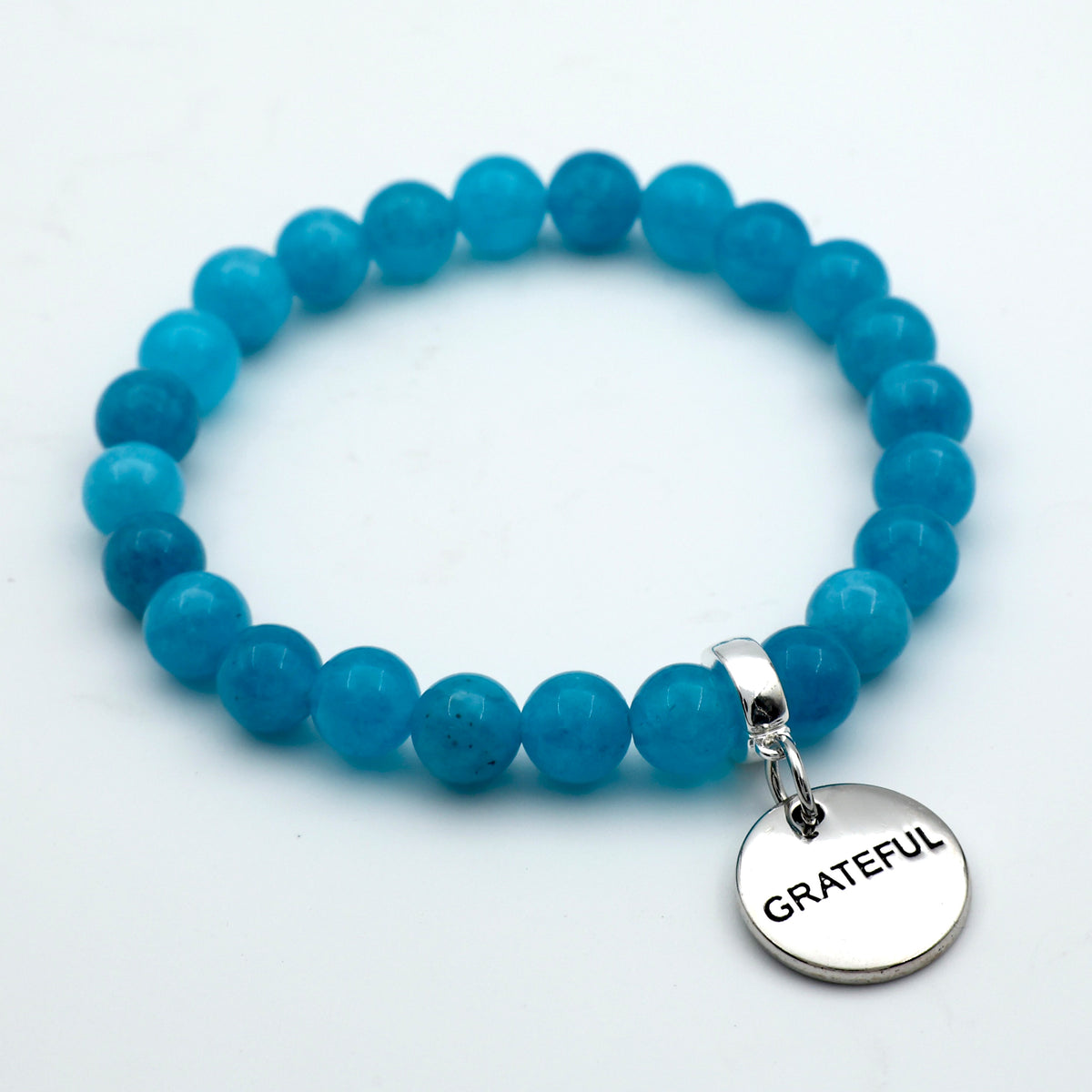 Blue beaded bracelet with a 'GRATEFUL' charm on a white background