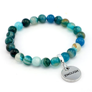 Multicolored beaded bracelet with a silver 'ENOUGH' charm on a white background