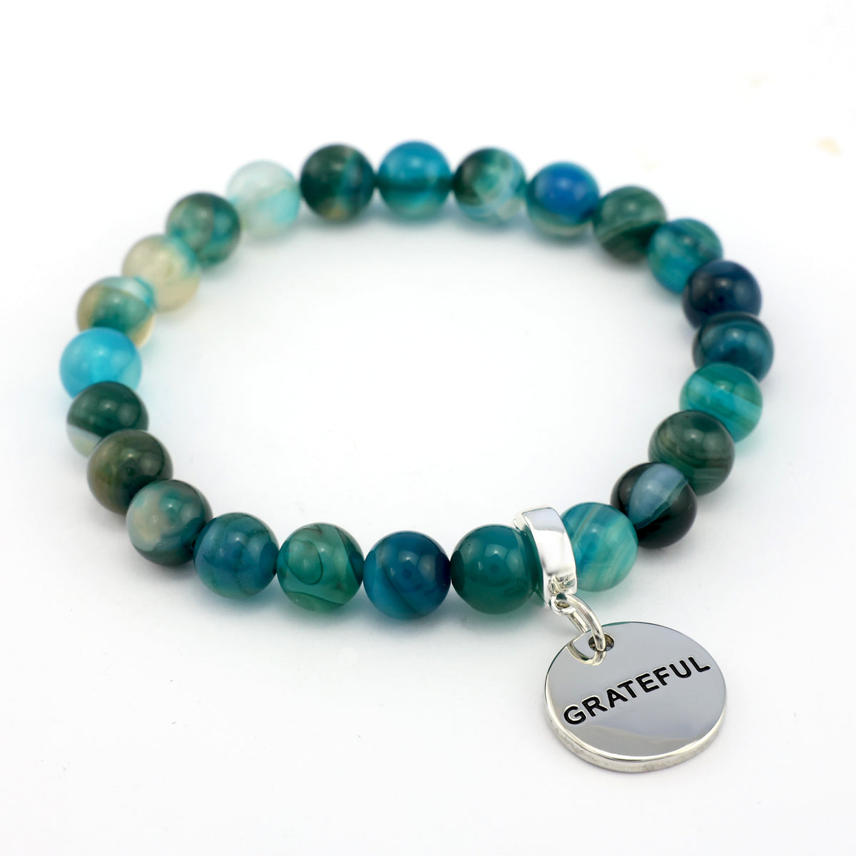 Teal beaded bracelet with a 'GRATEFUL' charm on a white background