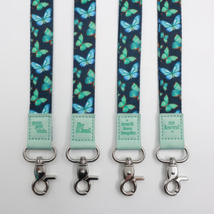 Teal Butterflies lanyards showing Be Kind, Teach Love Inspire, You Got This and So Loved embossed trims and lobster clasps.