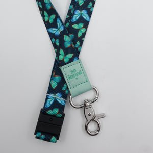 So Loved embossed on a navy lanyard with teal butterflies and mint trim and a lobster clasp.