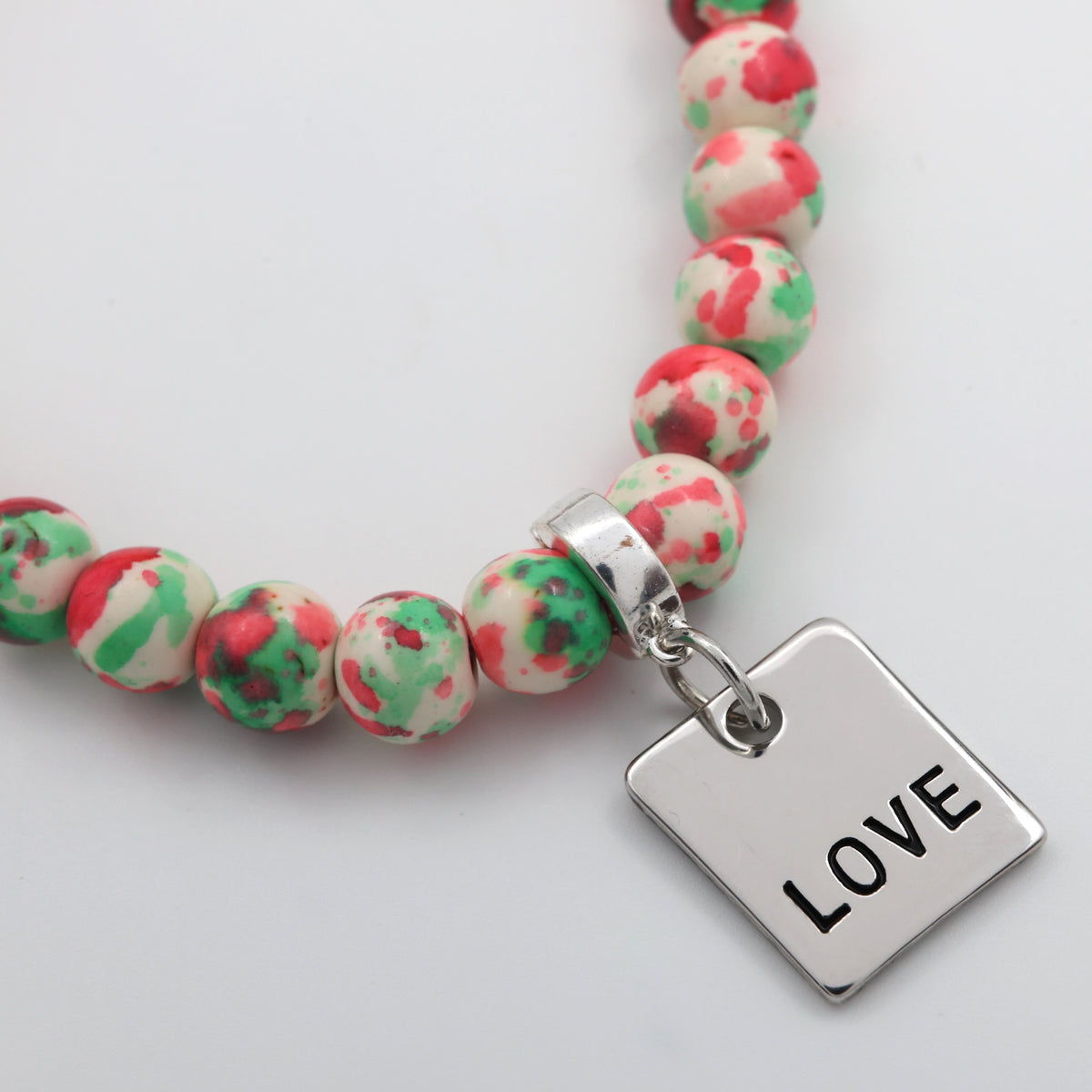 Beaded bracelet with a 'LOVE' charm on a light background