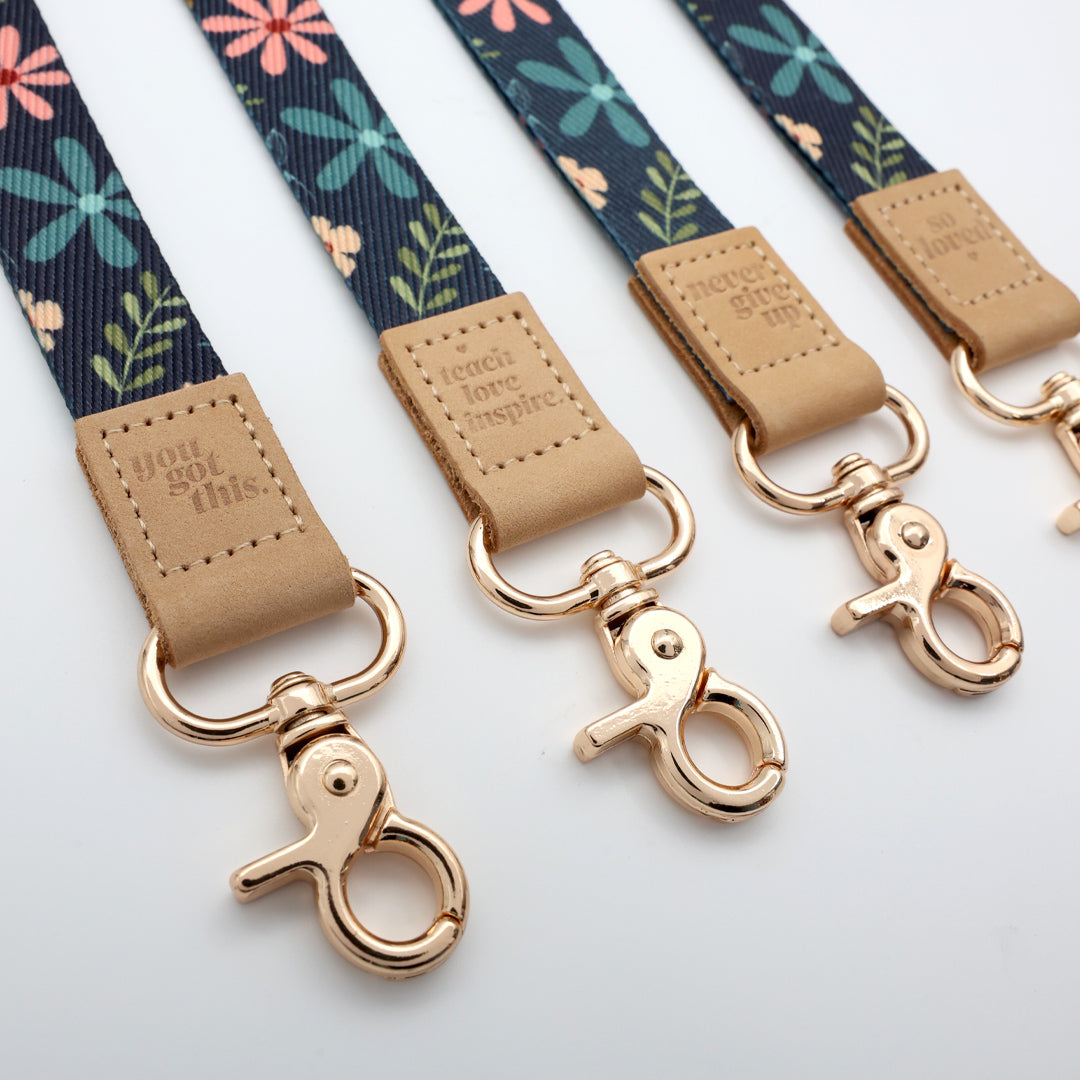 Floral patterned leashes with rose gold hardware on a light gray background