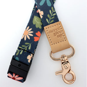 Floral-patterned keychain with 'never give up' tag on a white background