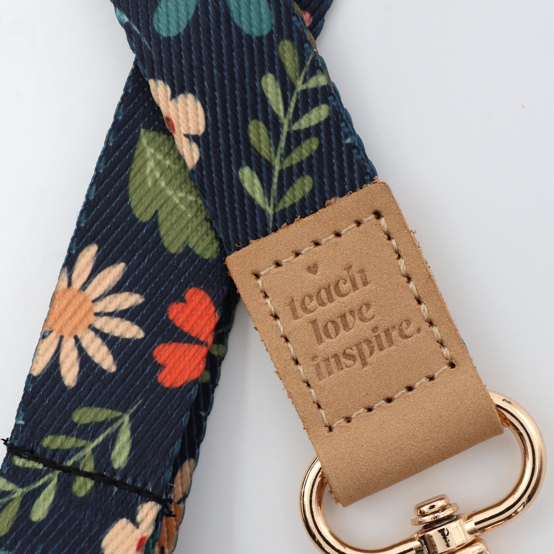 Four floral lanyards with motivational phrases and gold hooks on a white background