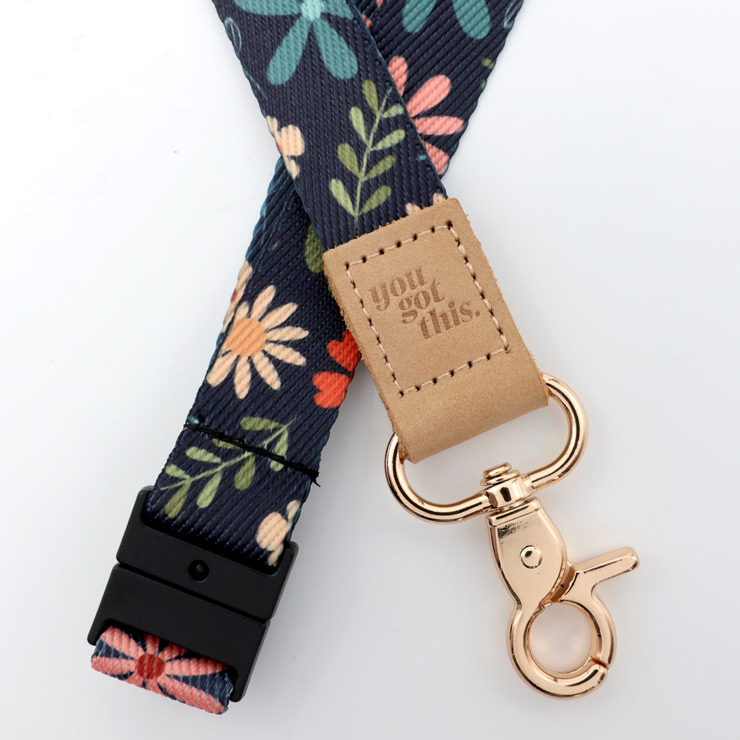 Floral-patterned lanyard with 'you got this' tag and rose gold clip on a white background