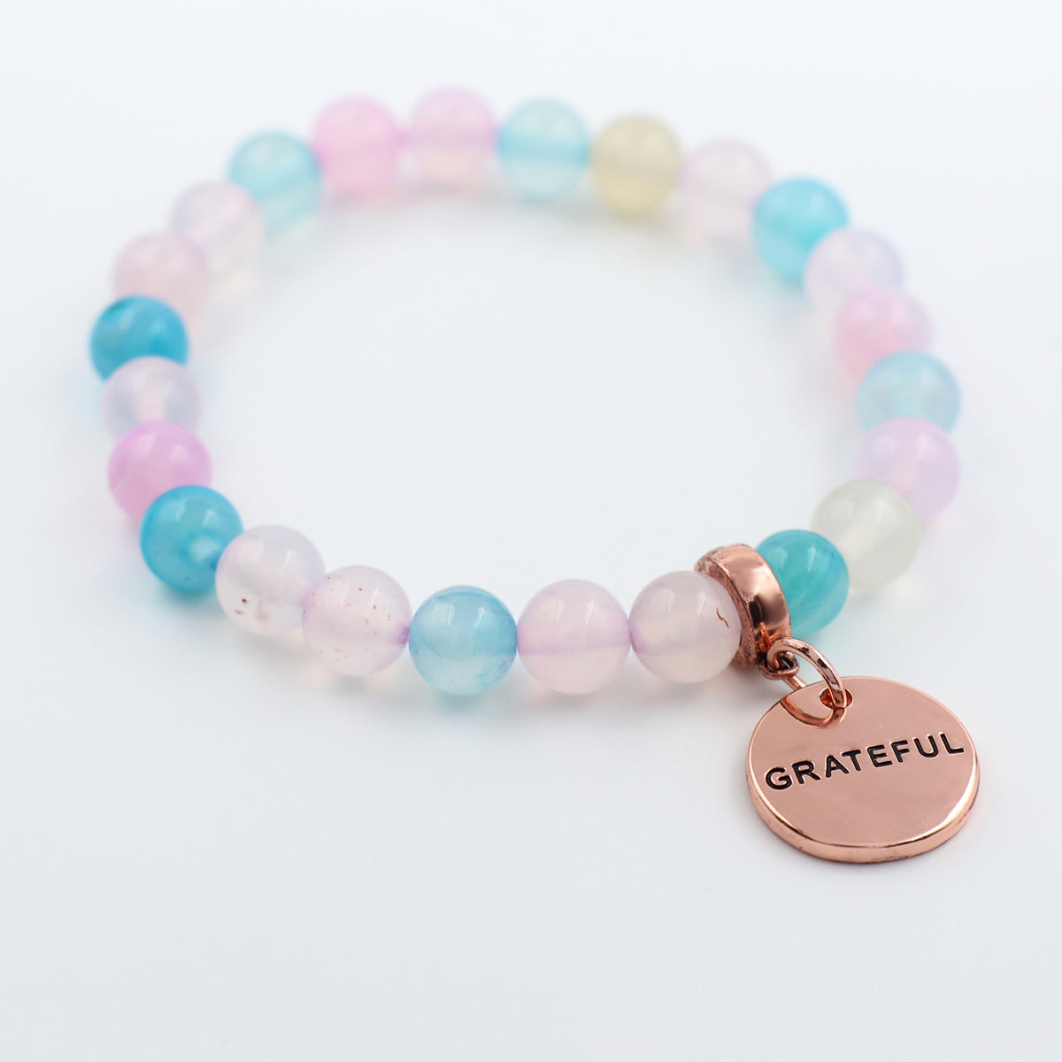 Multicolored beaded bracelet with a 'GRATEFUL' charm on a white background