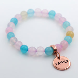 Multicolored beaded bracelet with a 'FAMILY' charm on a white background