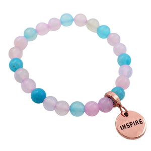 Multicolored beaded bracelet with a 'INSPIRE' charm on a white background