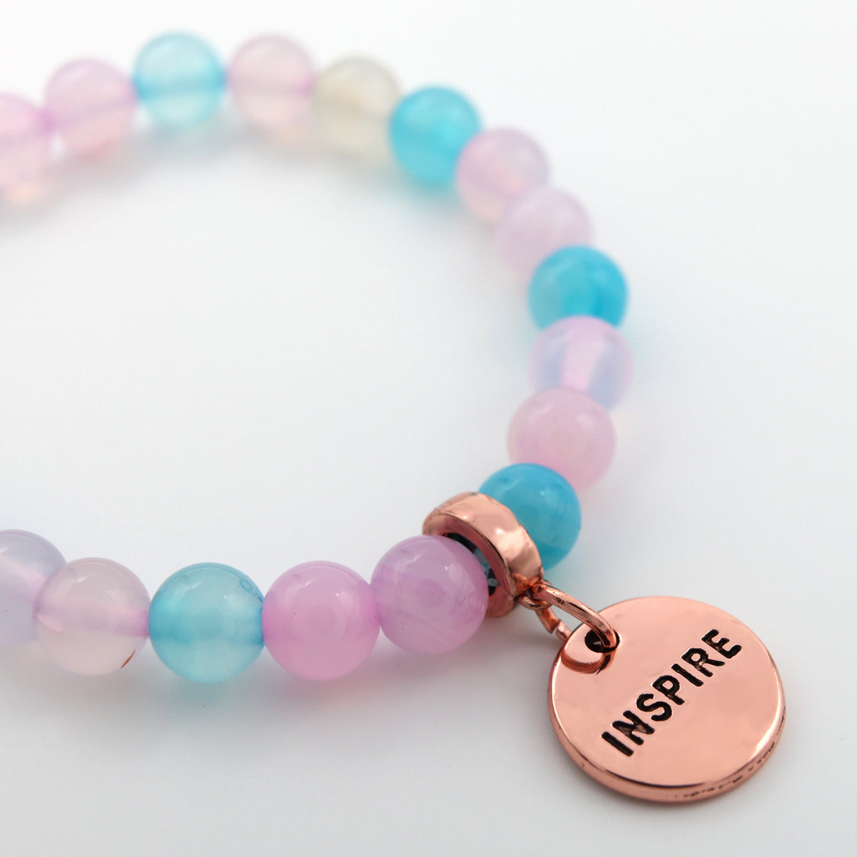 Multicolored beaded bracelet with a rose gold 'INSPIRE' tag on a white background