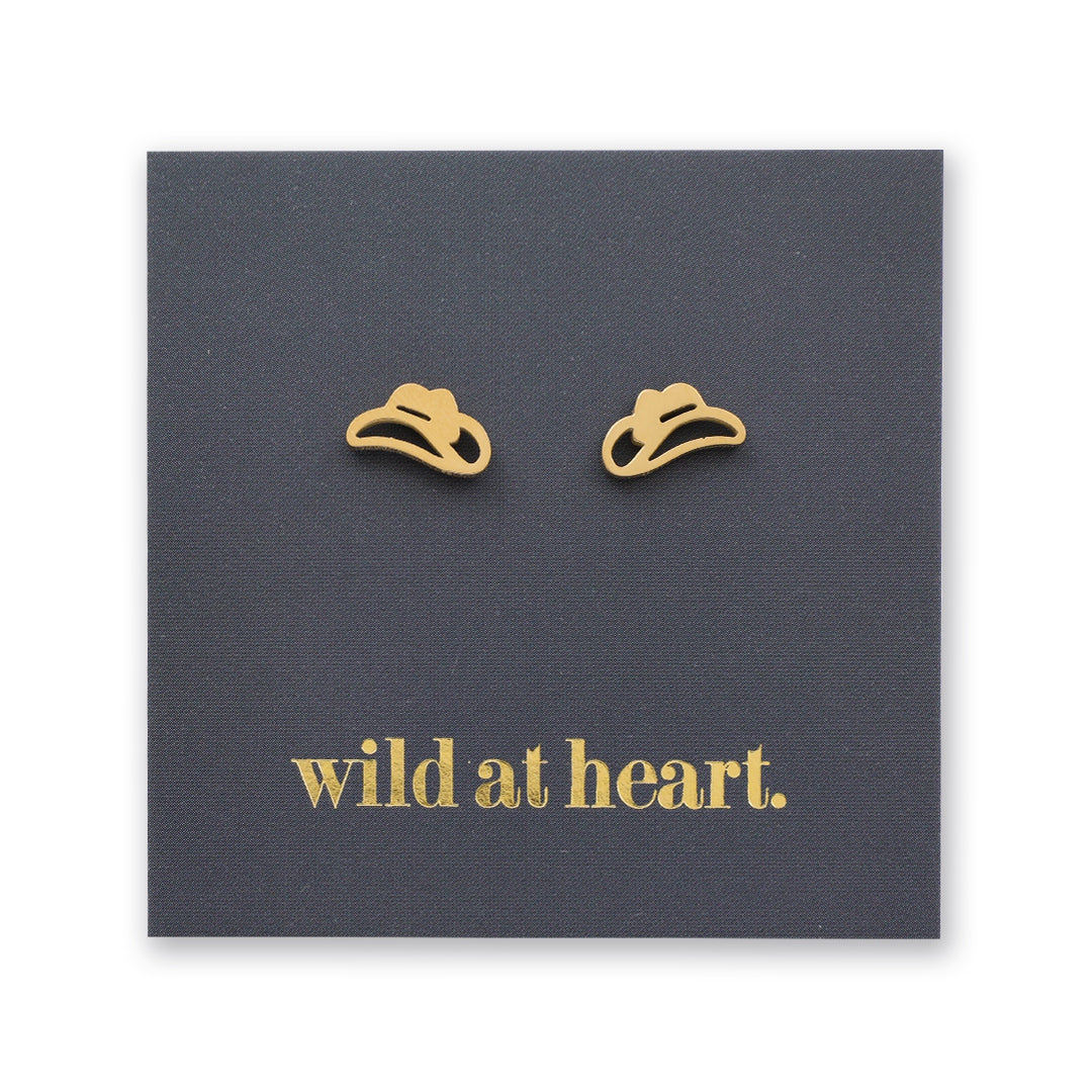 Gold cowgirl hat earrings on a black card with 'wild at heart.' text
