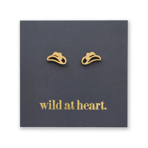 Gold cowgirl hat earrings on a black card with 'wild at heart.' text