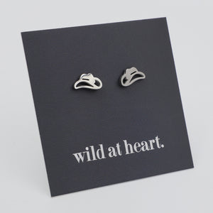 Silver cowgirl hat earrings on a black card with 'wild at heart.' text