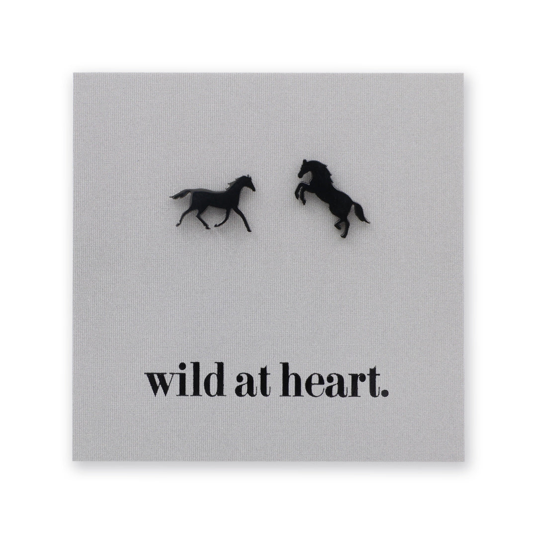 Black horse earrings on a black card with 'wild at heart.' text