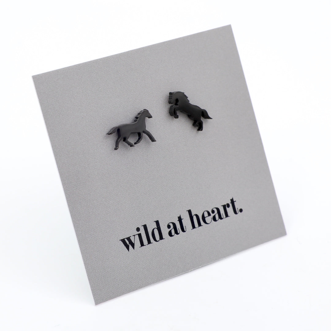 Black horse earrings on a black card with 'wild at heart.' text