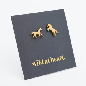 Gold horse earrings on a black card with 'wild at heart.' text 