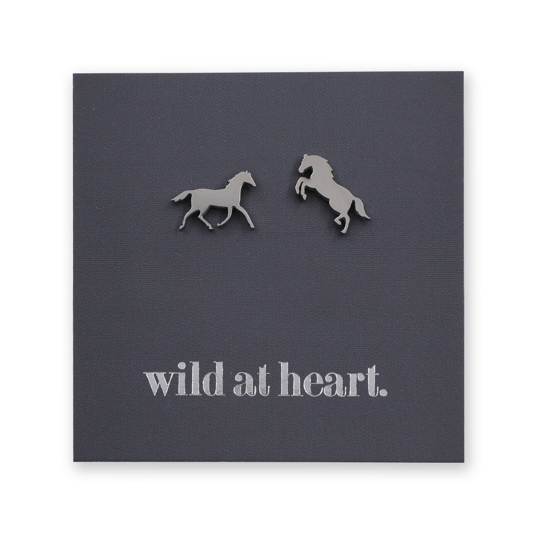 Silver horse earrings on a black card with 'wild at heart.' text