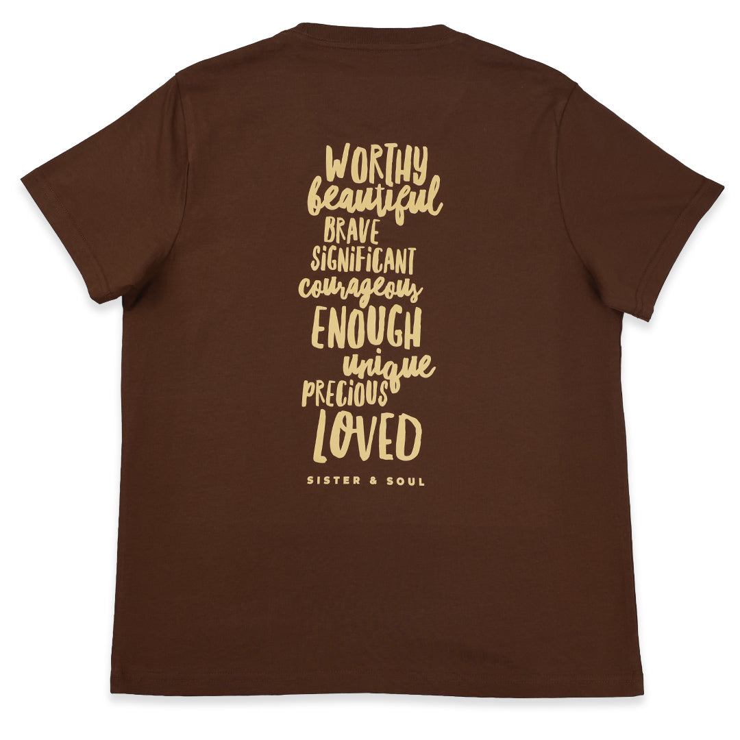 A brown short-sleeve t-shirt shown from the back, featuring a vertical stack of inspirational words in a textured beige font including 'WORTHY', 'BEAUTIFUL', 'BRAVE', 'SIGNIFICANT', 'COURAGEOUS', 'ENOUGH', 'UNIQUE', 'PRECIOUS', 'LOVED', and the brand name 'SISTER & SOUL' at the bottom.