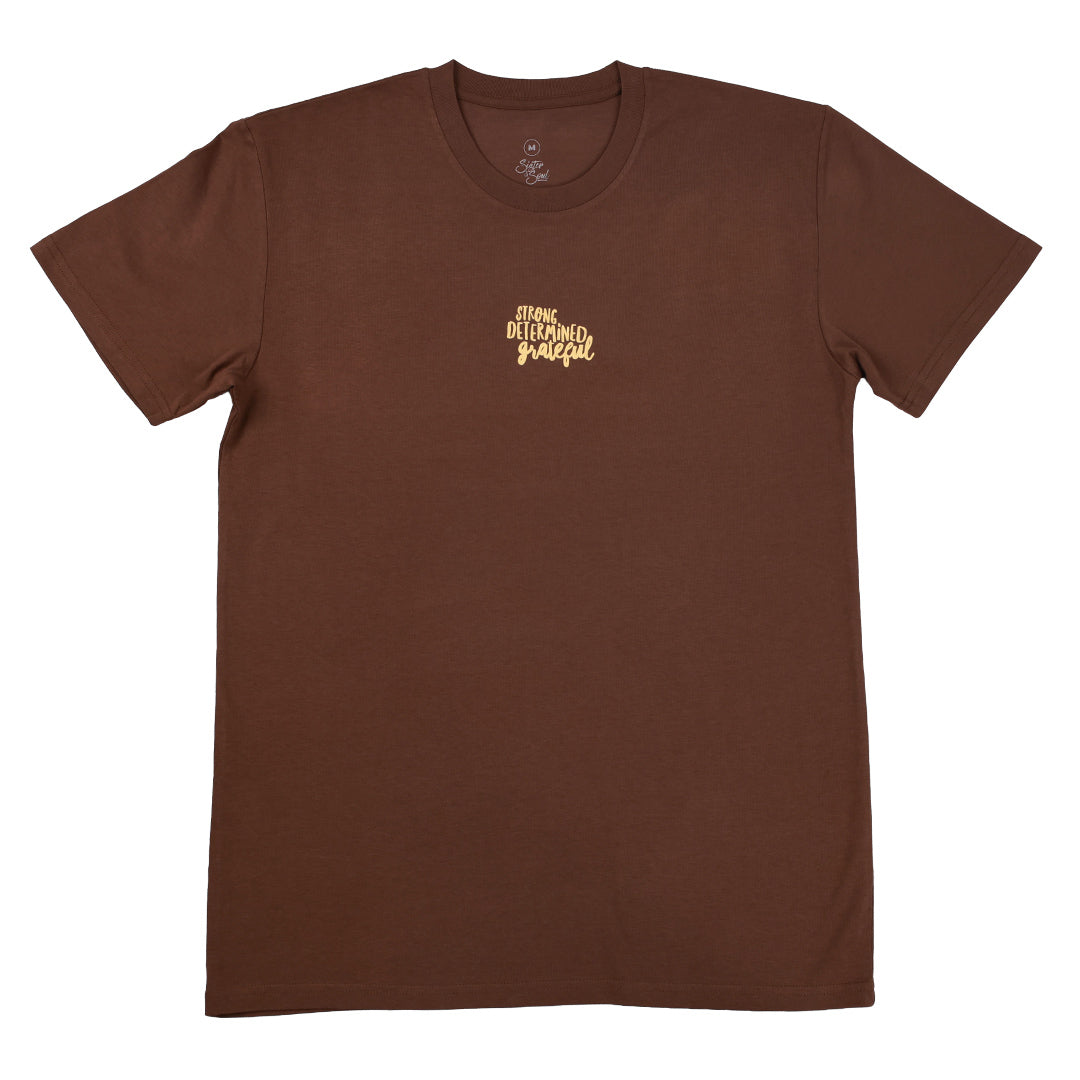 A brown short-sleeve crewneck t-shirt with a small gold graphic on the left chest that reads 'strong determined grateful'.